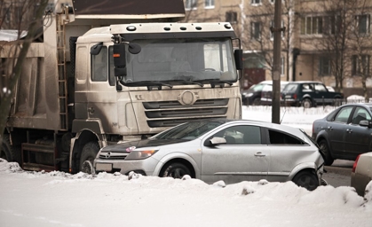 Garbage truck and cars driving on snowy road